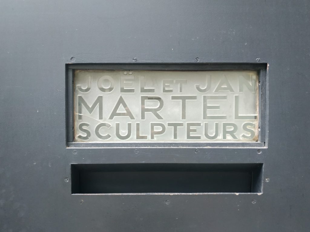 Plaque signée avec les noms des sculpteurs Joël et Jan Martel.