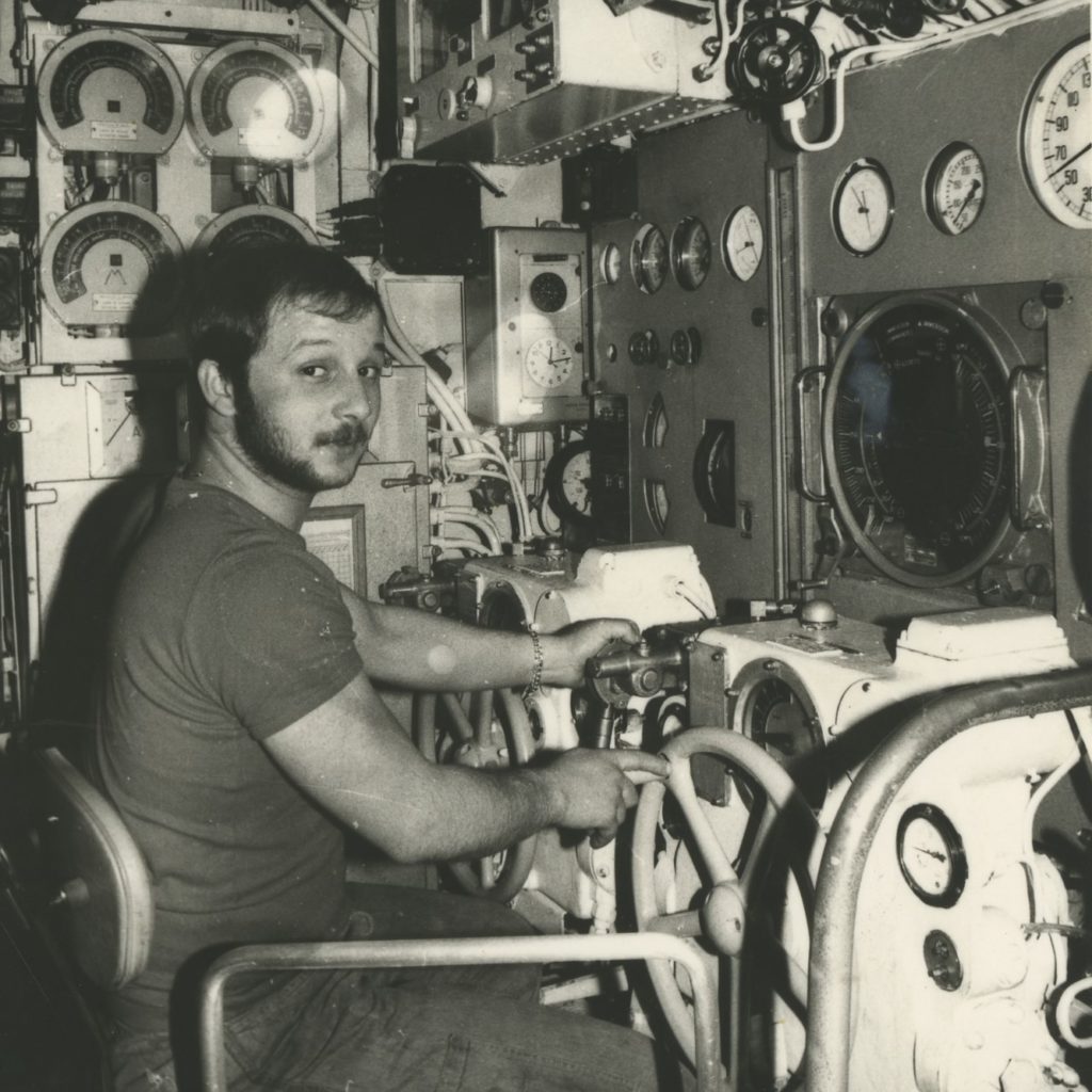 Photographie en noir et blanc d'un marin aux barres de plongée du sous-marin Espadon