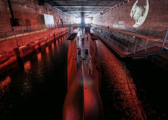 Sous-marin Espadon pris au niveau de la proue éclairé par des spots rouges.