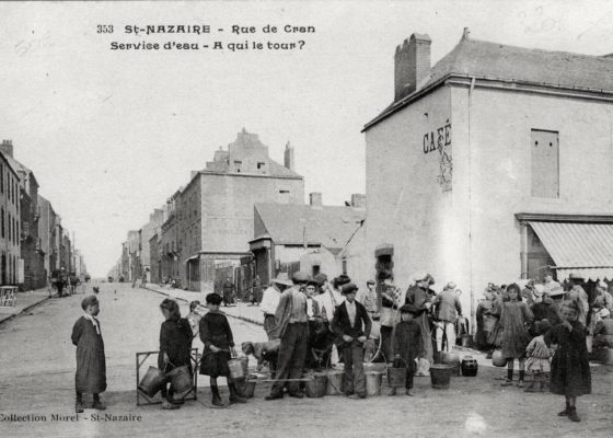 Photographe : inconnu. Éditeur : Morel. Collection Saint-Nazaire Agglomération Tourisme - Écomusée. Une foule attend son tour pour avoir de l'eau rue de Cran