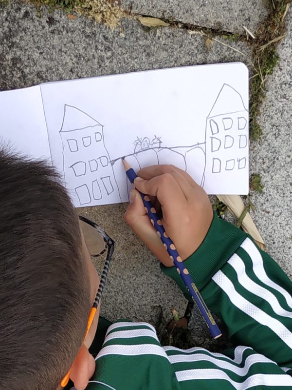 Un enfant dessinant un bâtiment.