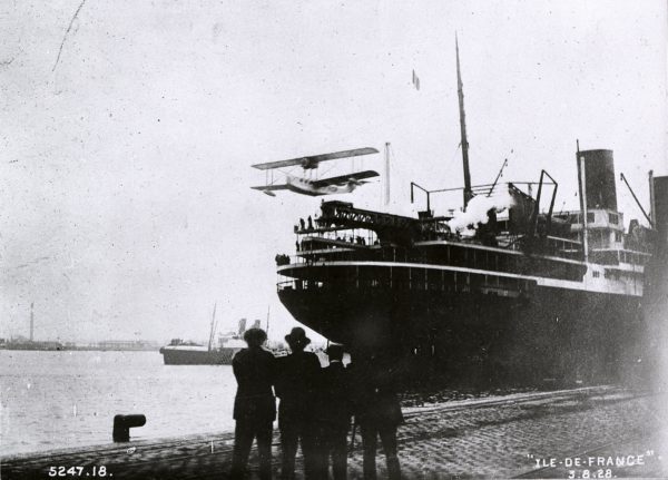 Des personnes assistent aux essais de catapultage d'un hydravion postal depuis le paquebot Ile-de-France (1927), le 3 août 1928 dans le bassin de Penhoët.