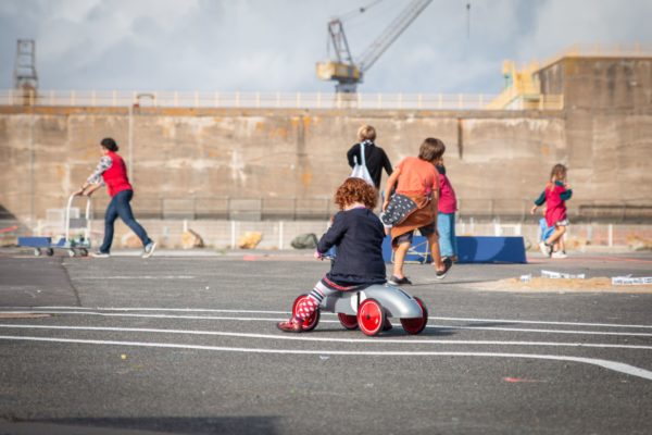 JEP 2019 à l'Écomusée. Jeux des années 1950. Une petite fille roule sur une petite voiture.