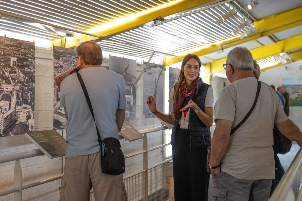 Une médiatrice de l'Écomusée présente l'exposition photographique temporaire "Saint-Nazaire, vue d'en haut" à des visiteurs.