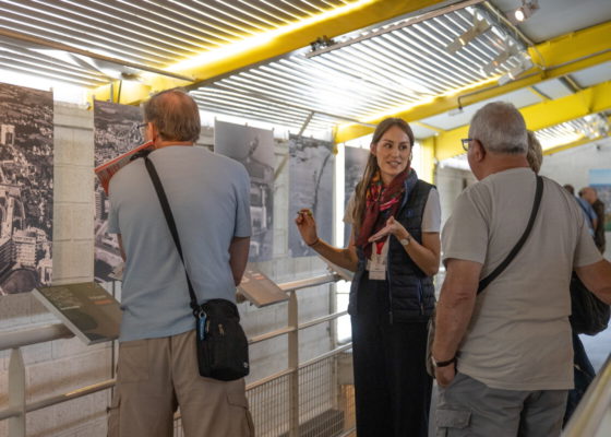 Une médiatrice de l'Écomusée présente l'exposition photographique temporaire "Saint-Nazaire, vue d'en haut" à des visiteurs.