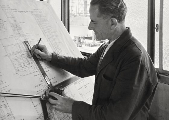 Photographie noir et blanc d'un dessinateur du bureau d’étude des machines des Chantiers de l'Atlantique.