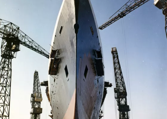 Photographe : inconnu. Collection Saint-Nazaire Agglomération Tourisme - Écomusée. Fonds Chantiers de l’Atlantique. Pose de la peinture sur la coque du paquebot France (1962), le 21 mars 1960.