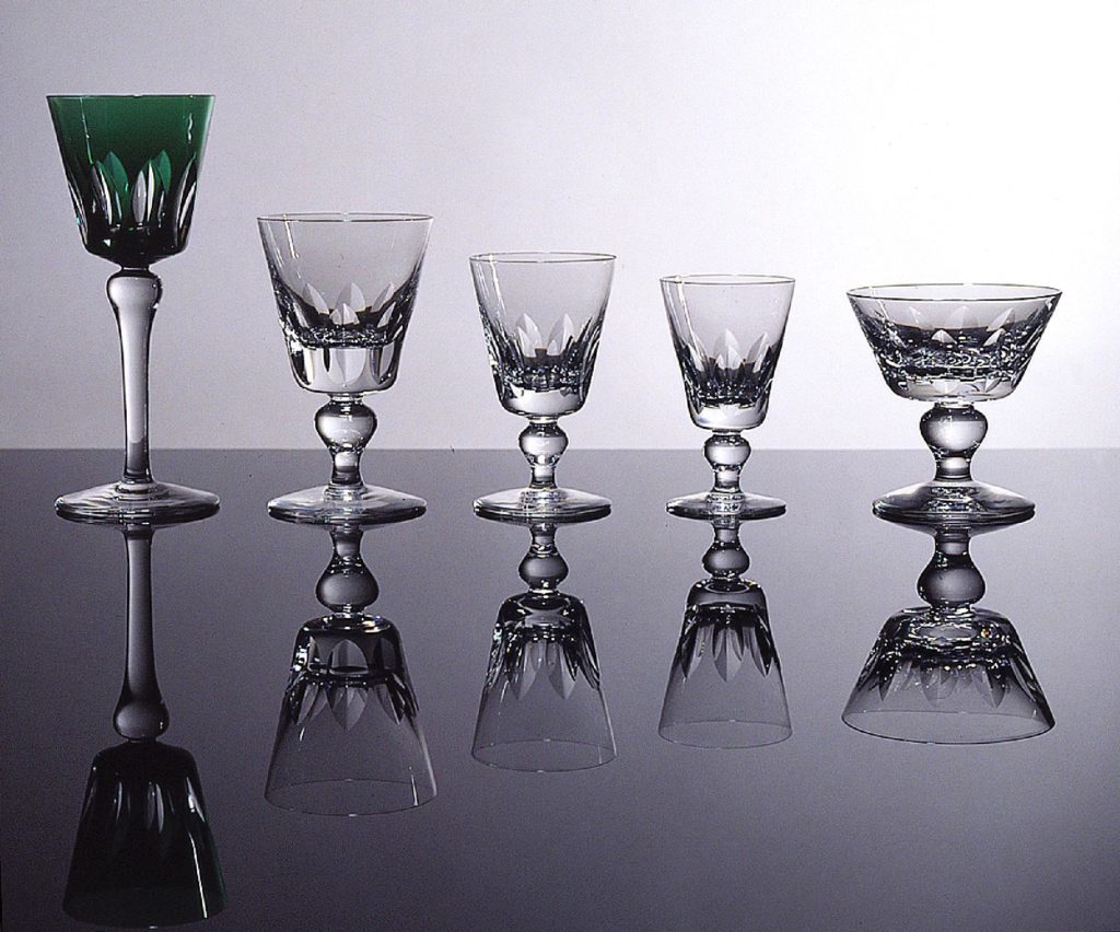 Cinq verres à vin dont une coupe à Champagne du paquebot France (1962) alignés.