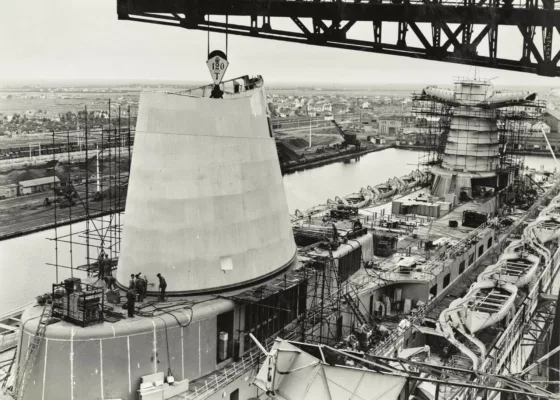 Photographe : inconnu. Collection Saint-Nazaire Agglomération Tourisme - Écomusée. Fonds Chantiers de l’Atlantique. Pose du fût de cheminée avant du paquebot France (1962), le 26 juin 1961.