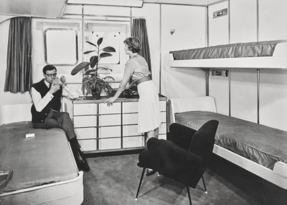Photographie noir et blanc d'un couple de passagers dans une cabine de classe touriste à quatre lits du paquebot France (1962).