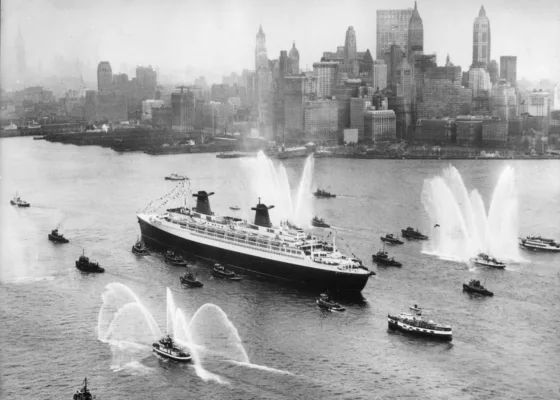 Photographe : inconnu. Collection Saint-Nazaire Agglomération Tourisme - Écomusée. Fonds Chantiers de l’Atlantique. Photographie noir et blanc du paquebot France (1962) arrive à New York lors de son voyage inaugural, le 8 février 1962.