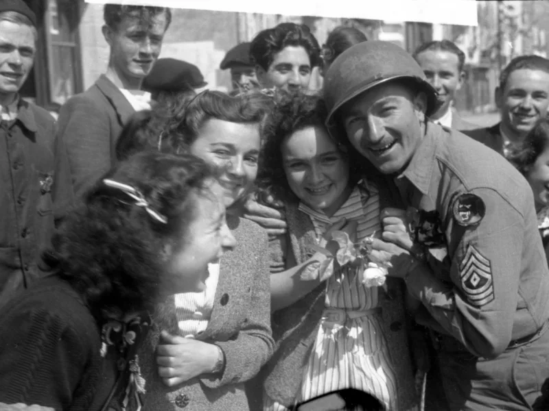 Photographie noir et blanc représentant des jeunes filles posant avec un soldat américain lors de la Libération au Pouliguen.