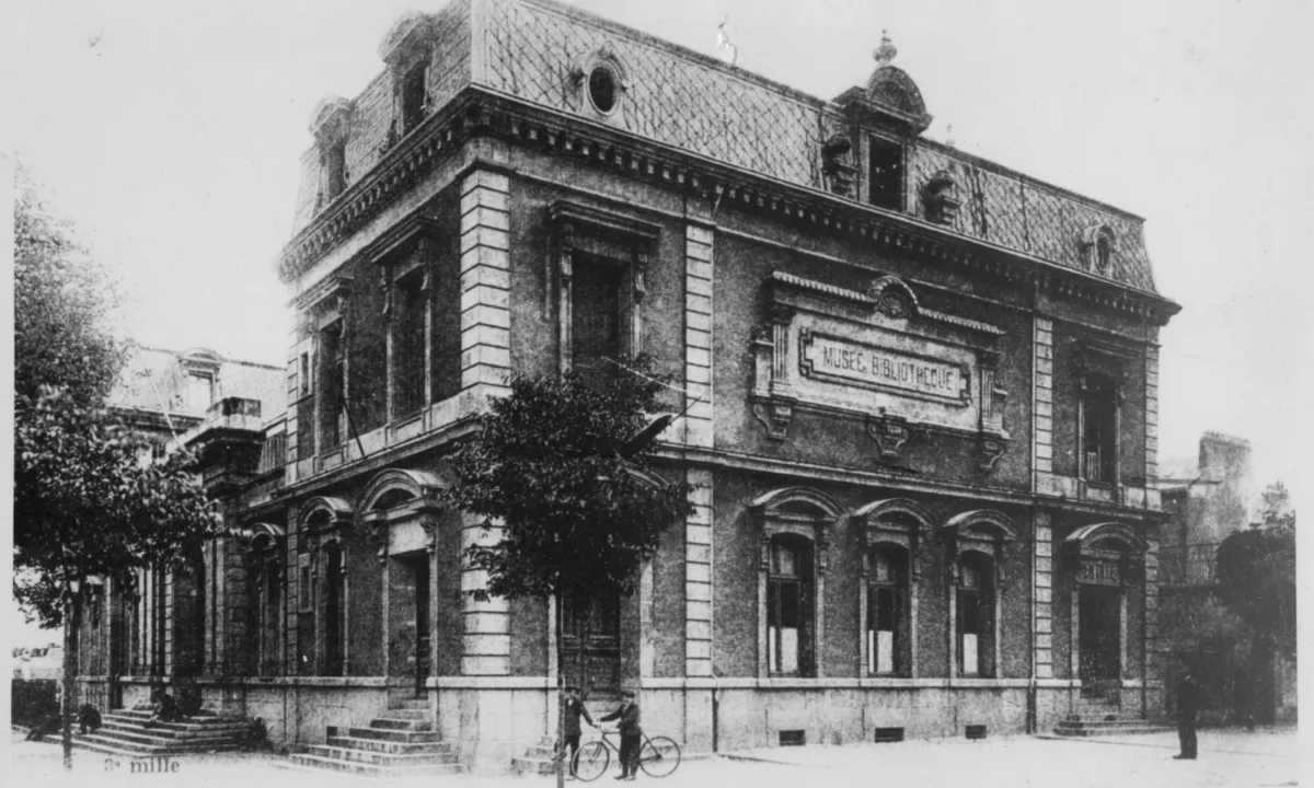 Photographie en noir et blanc du musée-bibliothèque vers 1908. Sur le pan droit du bâtiment, l'entrée de la Chambre de Commerce de Saint-Nazaire.