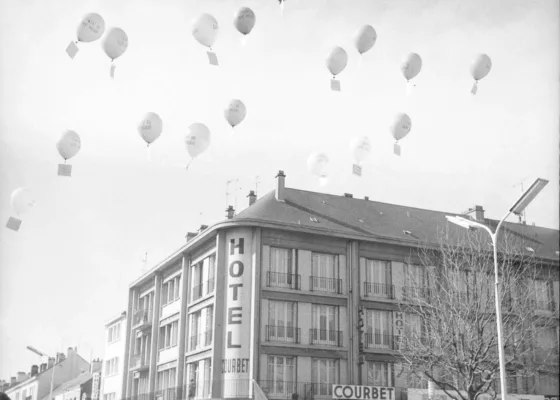 Photographie en noir et blanc représentant une foule rassemblée lors d'un lâcher de ballons lors d'une manifestation, sur la place de l'hôtel de ville à Saint-Nazaire.