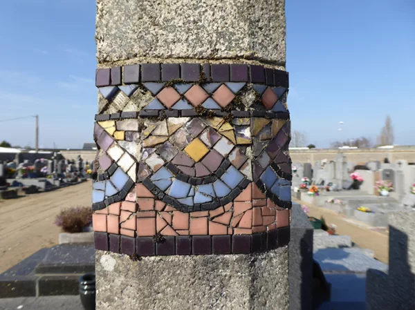 Mosaïque aux motifs géométriques colorés sur une colonne dans le cimetière de Méan-Penhoët à Saint-Nazaire.