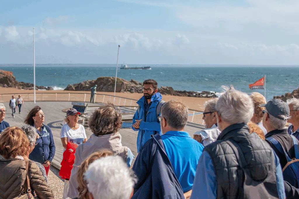 Photographe : Jérôme Bosger. Saint-Nazaire Agglomération Tourisme. Guide s'adressant à un groupe de visiteurs lors d'une visite dans le quartier de Saint-Marc pendant les Journées du patrimoine, événement de la Saison patrimoine 2019.